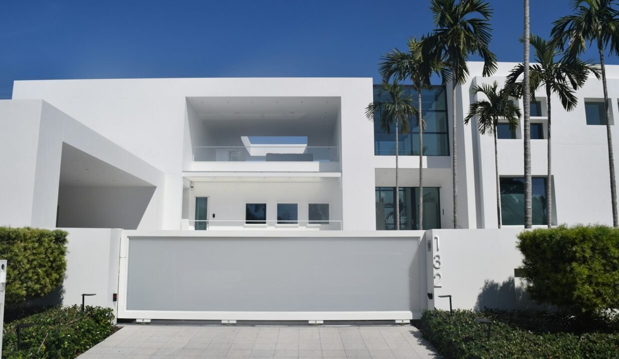 white concrete building with green plants on the side