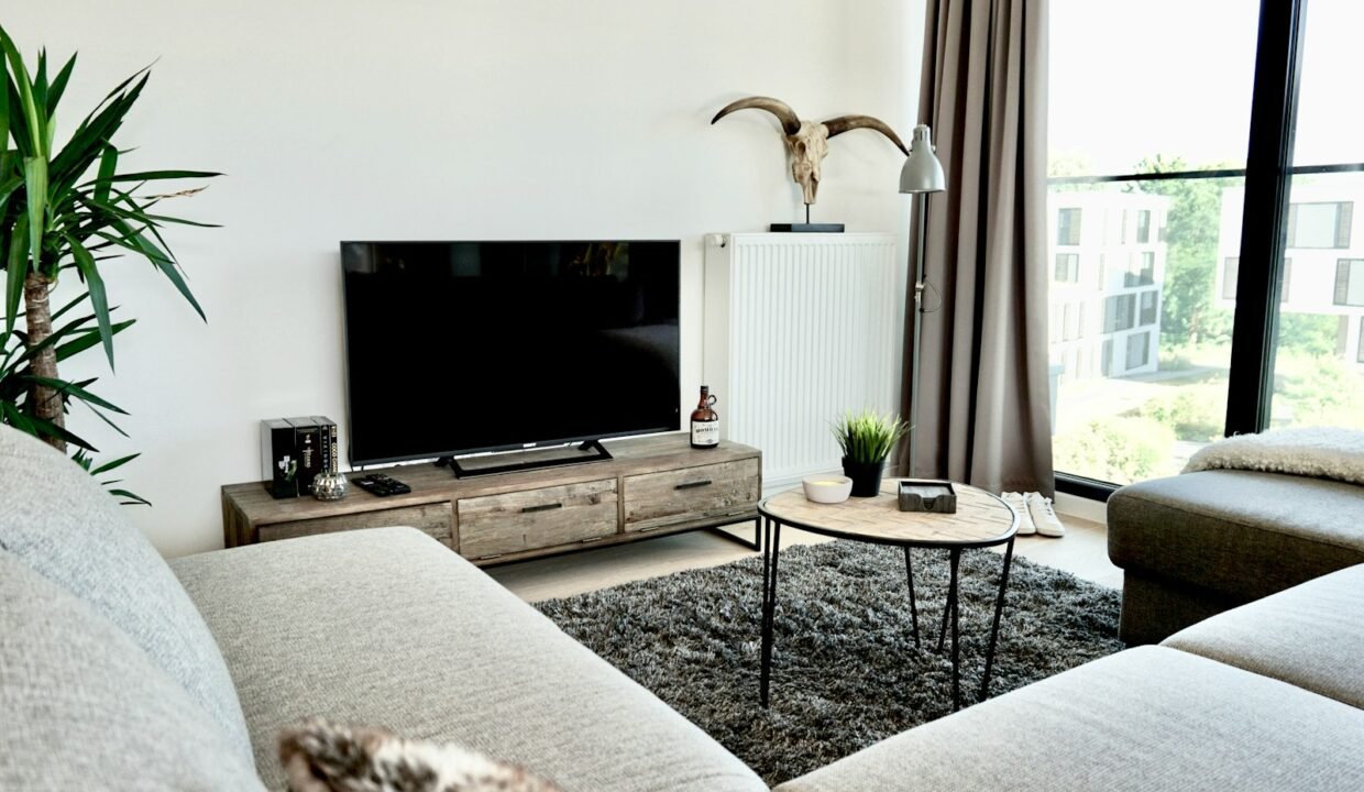 black flat screen tv on brown wooden tv rack